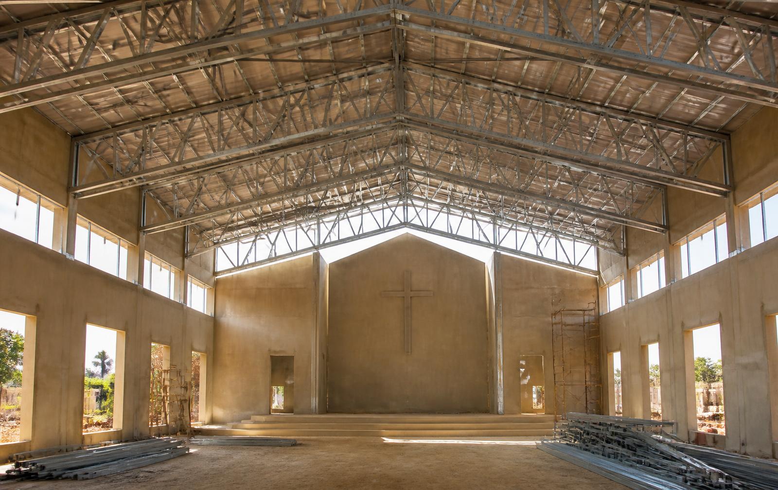 Steel roof trusses spanning a church auditorium under construction